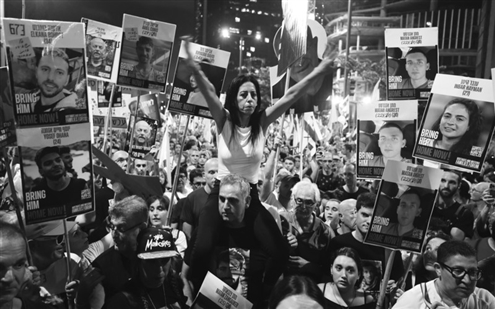 8月9日,以色列民众手持被扣押人员的海报在特拉维夫参加游行集会。新华社发